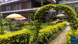 A building with a stone facade, a balcony with a white railing, and a sign that reads "OLAY INN". - Galaxy Inn Guest House (Pokhara)