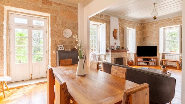 Un salón espacioso con una mesa de comedor de madera, un sofá y una chimenea.