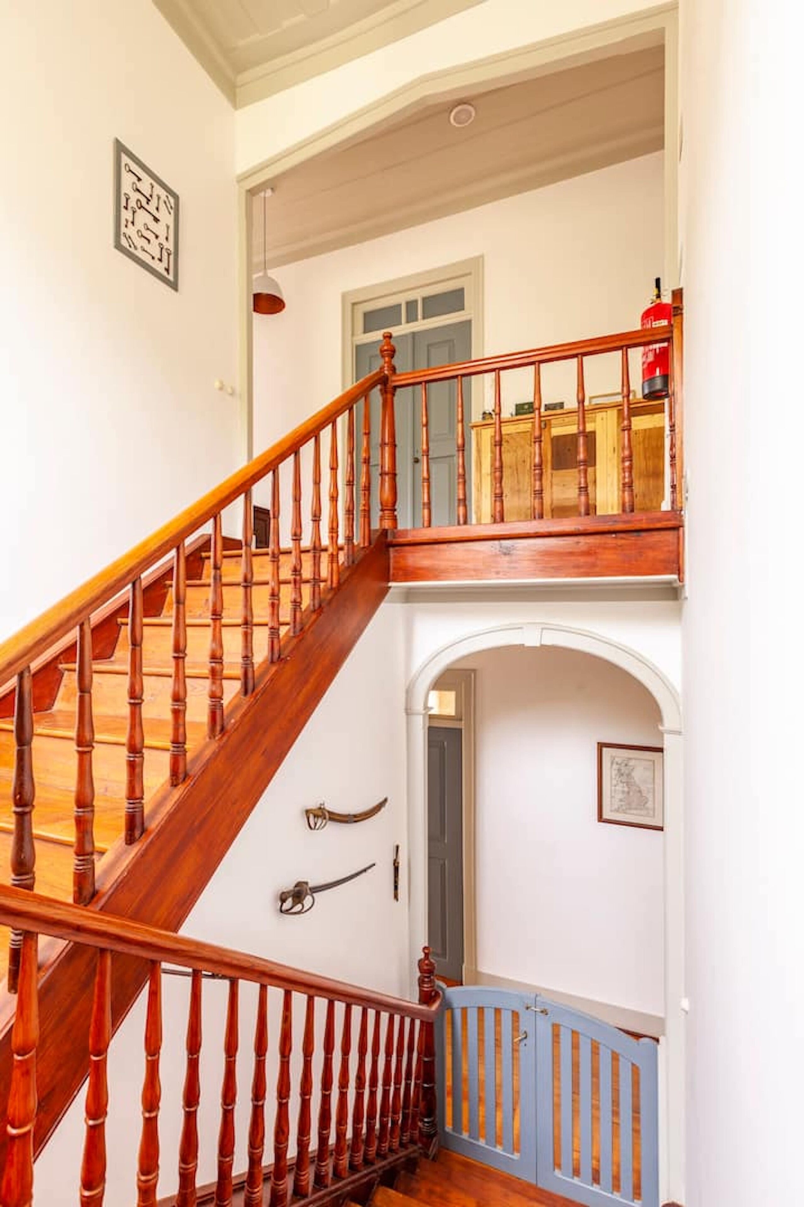 A wooden staircase with a blue railing leading to a balcony.