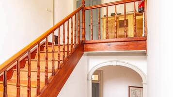 A wooden staircase with a blue railing leading to a balcony.