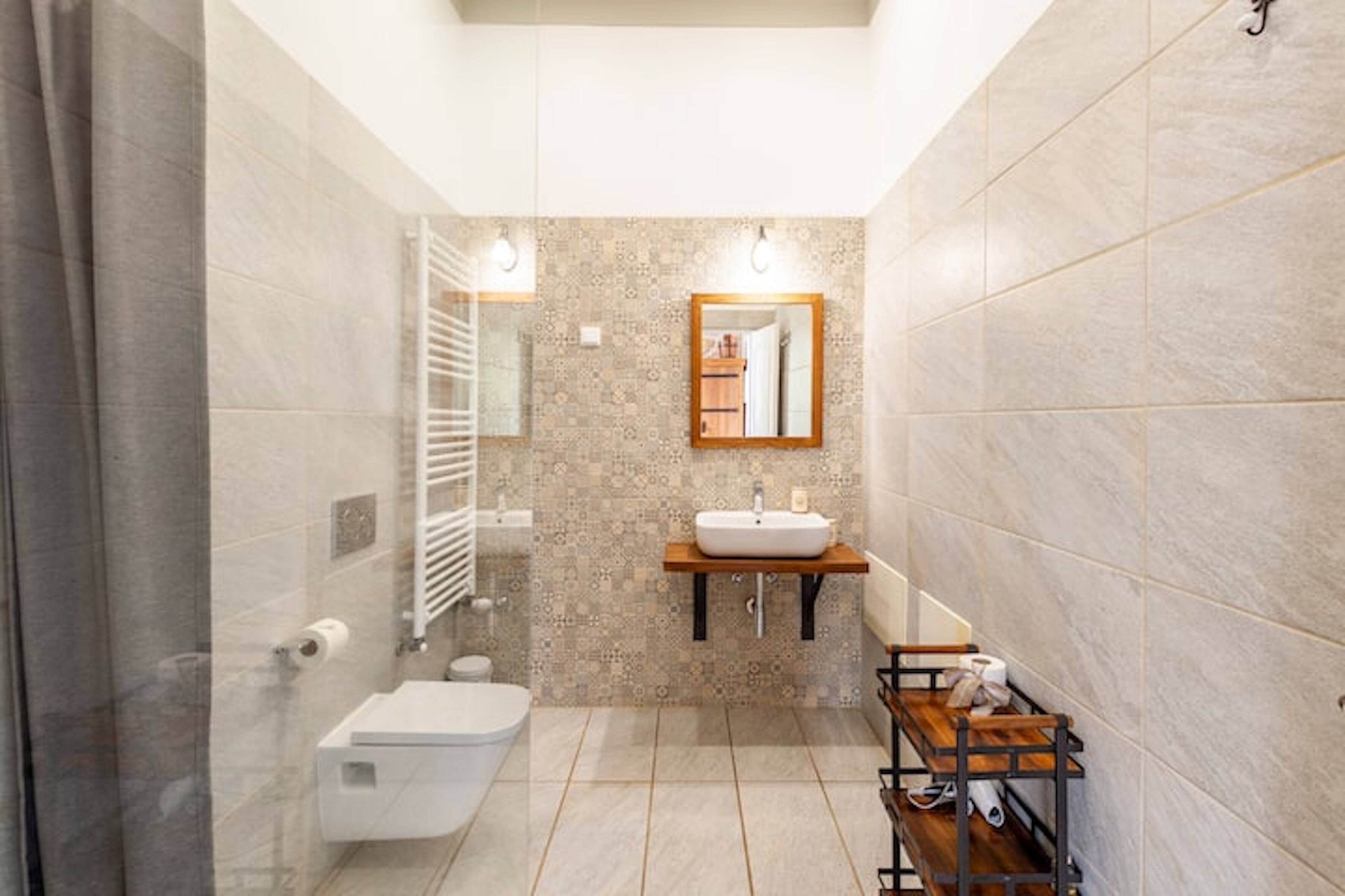 Une salle de bain moderne équipée de toilettes, d’un lavabo et d’un espace douche.
