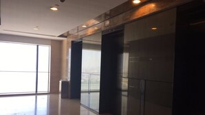A spacious, modern lobby with a large glass door leading to a balcony with a city view. - Checkinn Business Apartment-Poly World (Guangzhou)