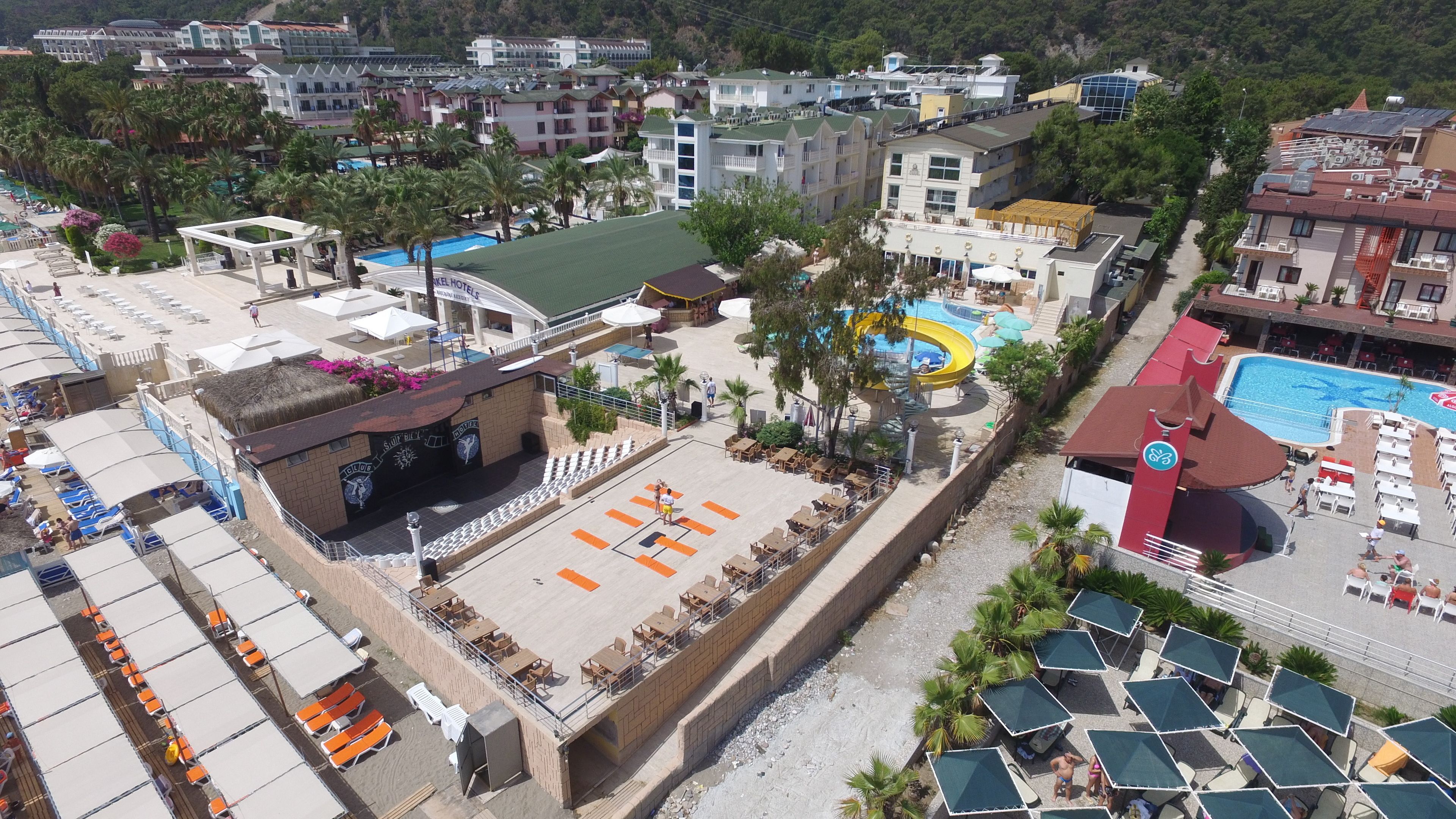 An aerial view of a resort with multiple buildings, a swimming pool, and outdoor seating areas.