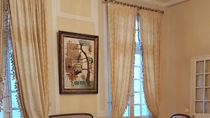 A room with a chandelier, striped sofas, a patterned rug, and a framed artwork on the wall. - Hôtel Cardinal (Aix-en-Provence)