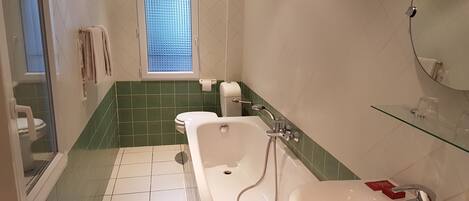 A bathroom with a bathtub, a toilet, and a sink.