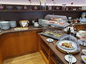 Un buffet con diversi cibi, piatti e posate.