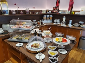 Una mesa de buffet con diversos alimentos y acompañamientos.