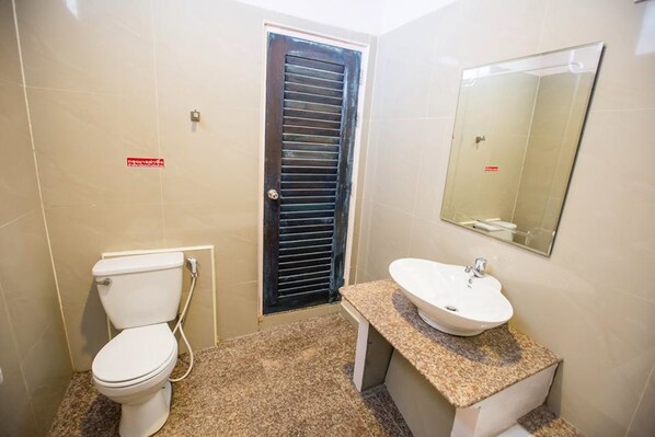 Un baño pequeño con inodoro, lavamanos y espejo.