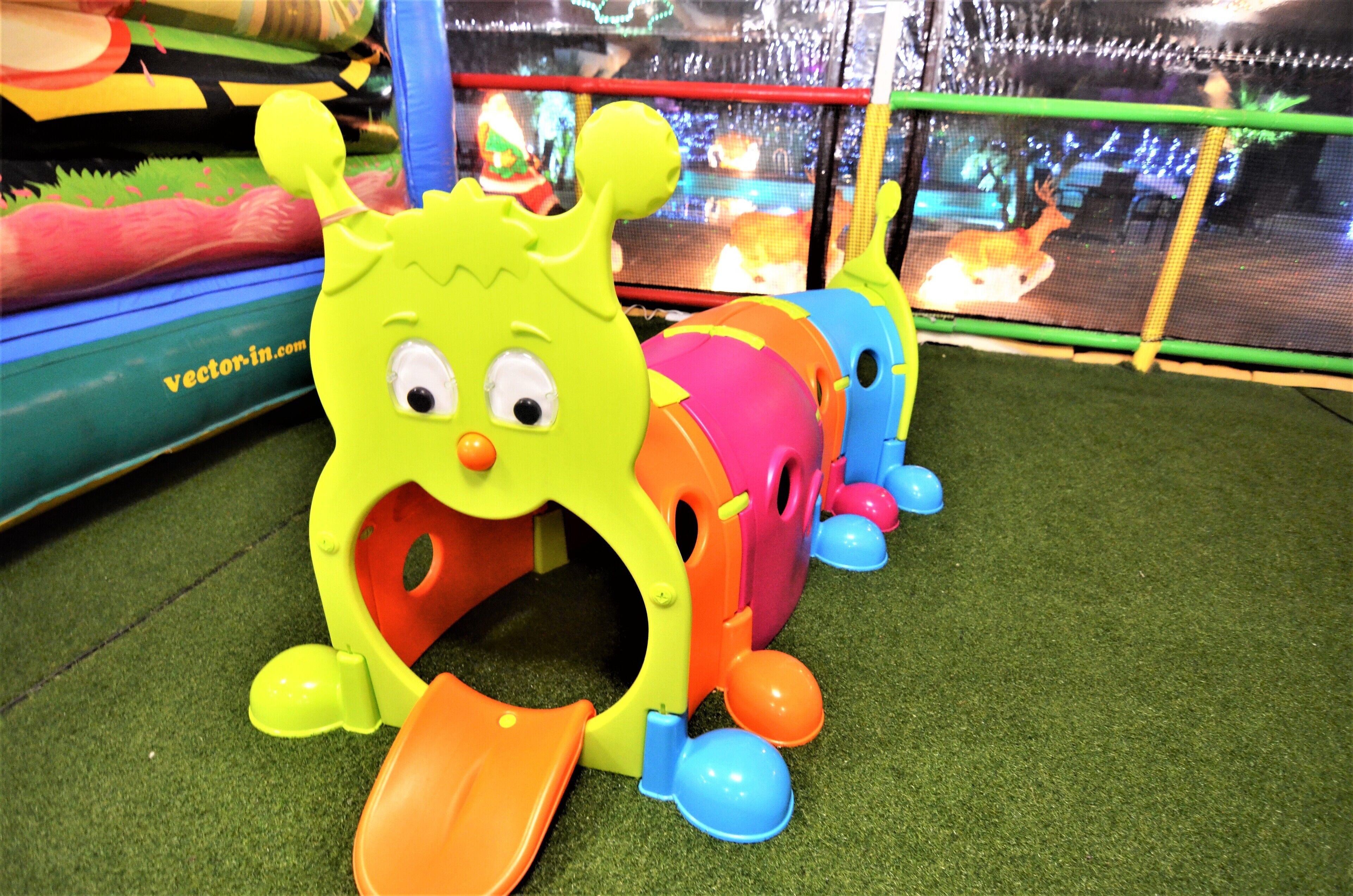 A children's play area with a brightly colored monster toy and a slide.