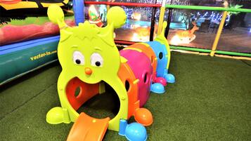 A children's play area with a brightly colored monster toy and a slide.