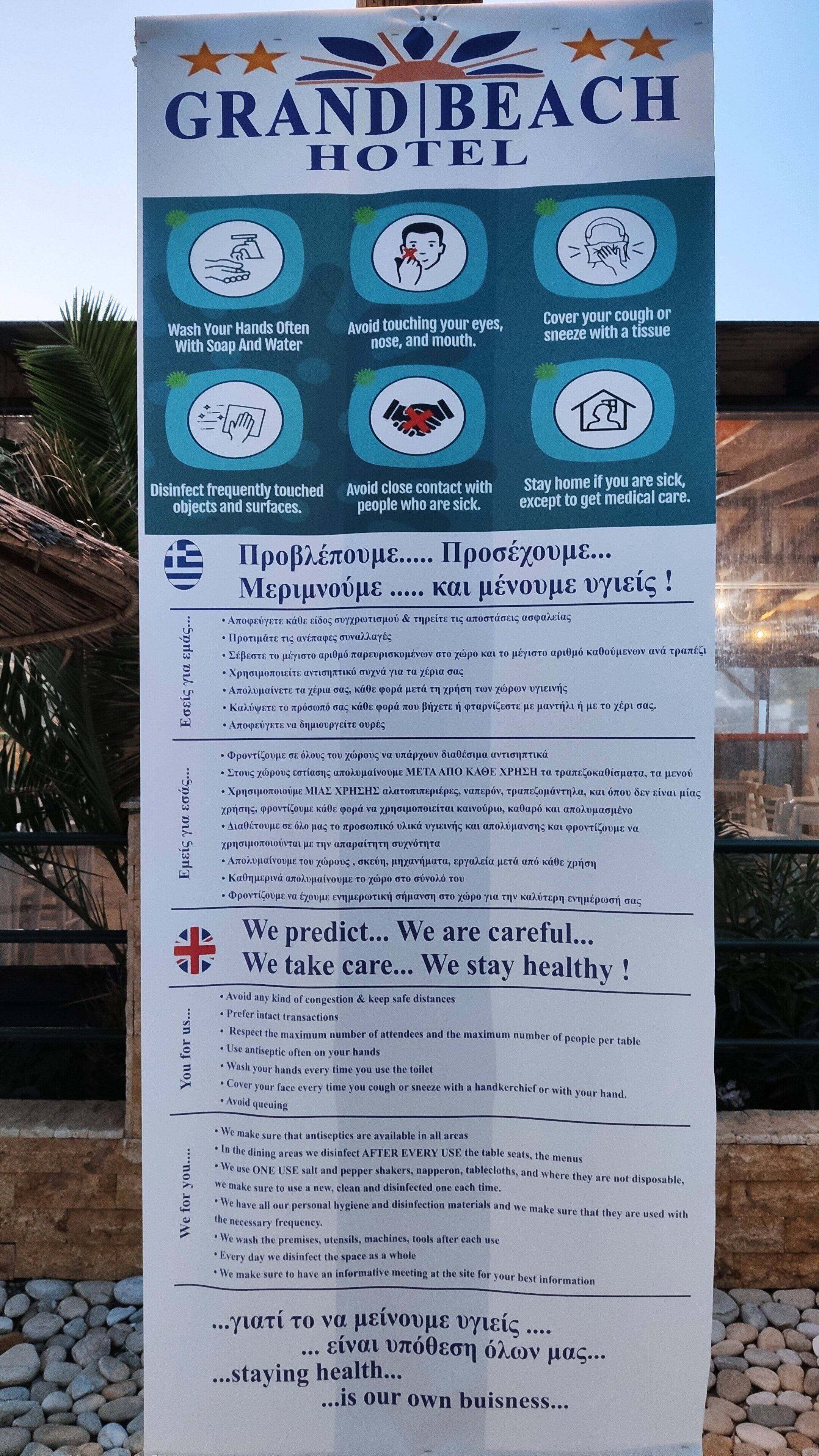 A Grand Beach Hotel sign with health and safety guidelines.