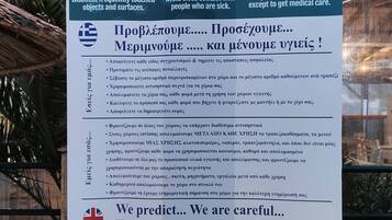 A Grand Beach Hotel sign with health and safety guidelines.