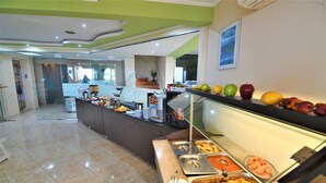 Zona de buffet amb diversos plats i una vitrina de cristall.