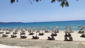 En la playa, camastros, sombrillas y toallas de playa 