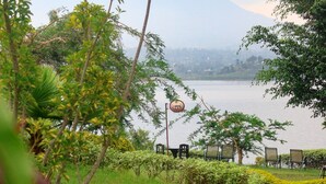 A lakeside view with a gazebo, chairs, and a sign indicating a restaurant.