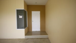 A hallway with a white door and a window with a label.