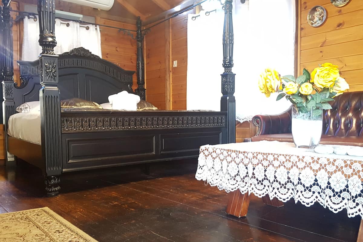 Un lit à baldaquin en bois, avec un oreiller blanc et une nappe en dentelle.