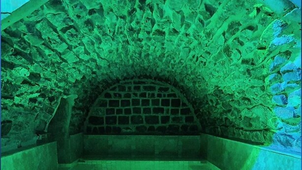 An arched stone structure with a pool. - Lake Mansion (Tiberias)