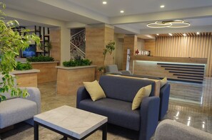 A modern lobby with a reception desk, seating area, and a staircase. - Afsin Hotel (Konyaalti)