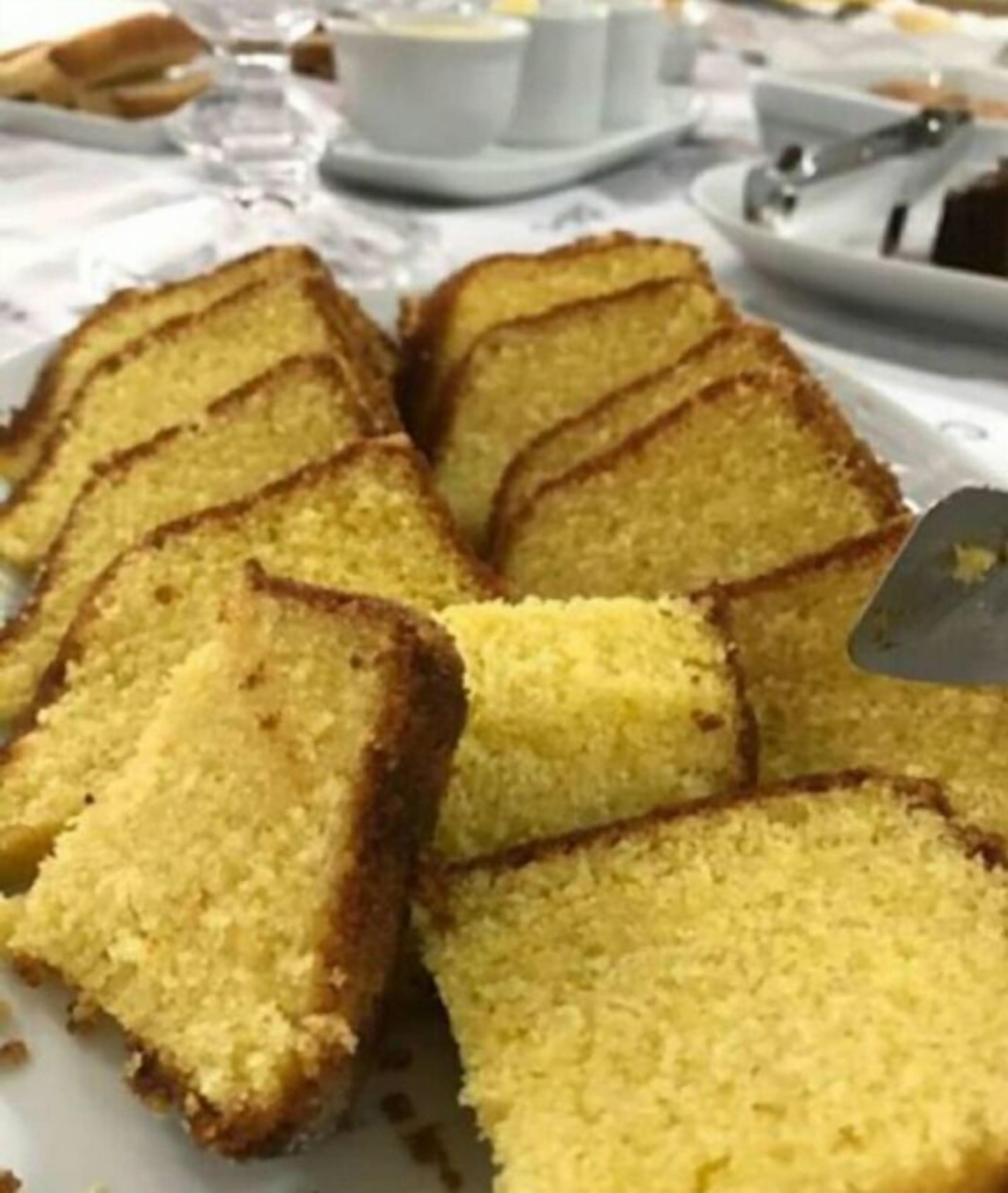 A plate of square-cut yellow cake slices on a white plate.