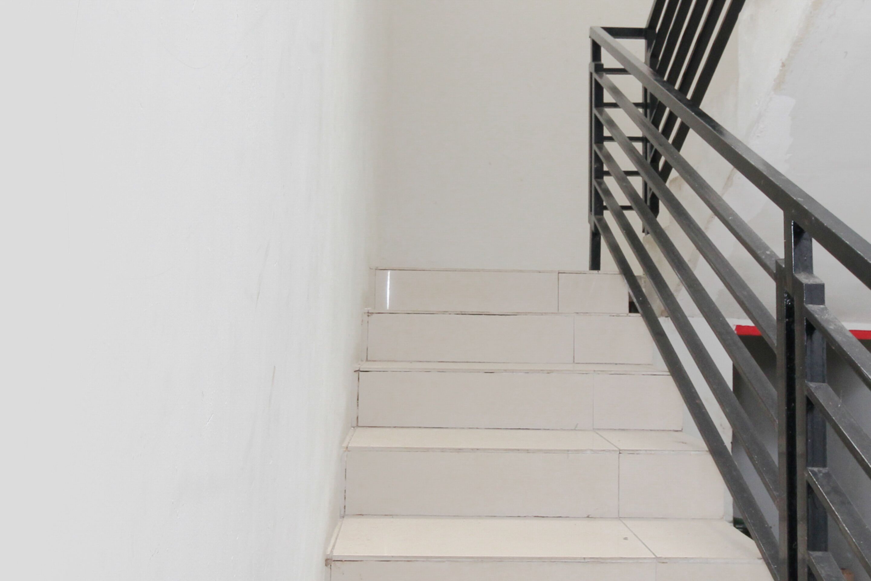 A staircase with white steps and a black metal railing.