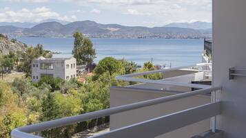 Un balcón con vista a un lago, montañas y un pueblo a lo lejos.