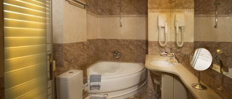 A bathroom with a bathtub, toilet, sink, and a mirror.