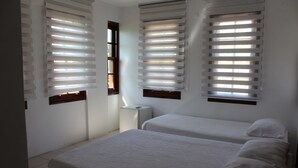 A room with two beds, white bedding, and a window with blinds. - White City Pension (Antalya)