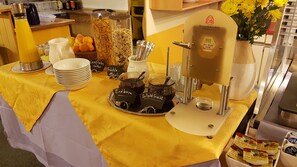 Ein Frühstücksbuffet mit verschiedenen Speisen und einer Kaffeemaschine.