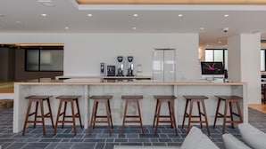 A modern kitchen with a central island, bar stools, and a large screen. - Ariston Hotel Kyoto Jujo (Kyoto)