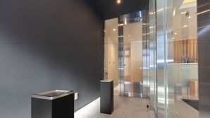 A modern lobby with a glass partition, a reception desk, and a staircase leading to an elevator. - Ariston Hotel Kyoto Jujo (Kyoto)