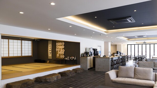 A modern interior with a tatami mat area, a bar, and seating. - Ariston Hotel Kyoto Jujo (Kyoto)