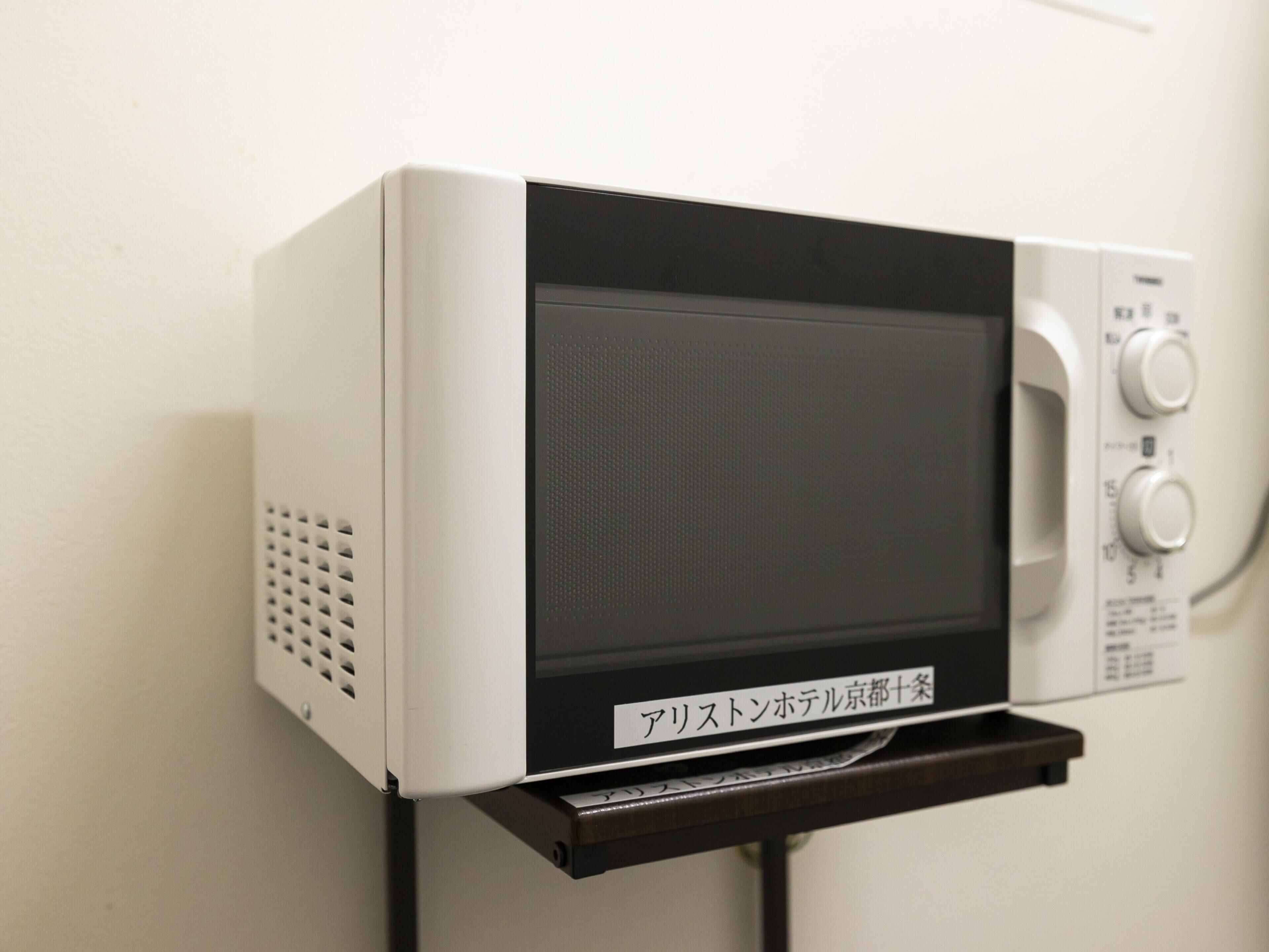 Een magnetron aan de muur bevestigd, met een bedieningspaneel aan de rechterkant.