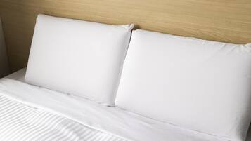 Un lit avec une literie blanche et une tête de lit en bois.