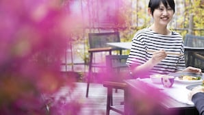 A person dining at an outdoor table with chairs, a tablecloth, and a decorative item. - Ariston Hotel Kyoto Jujo (Kyoto)