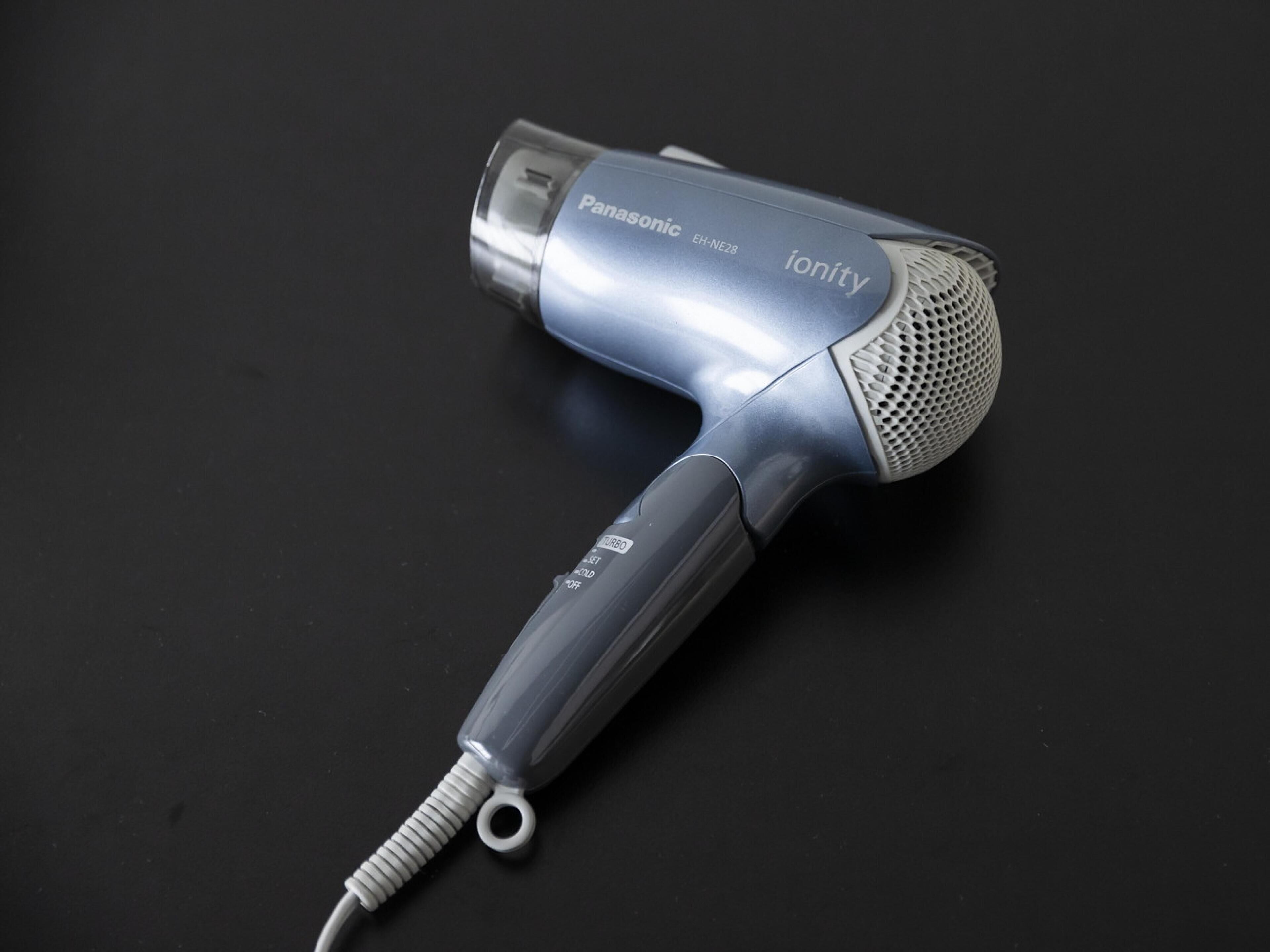 A Panasonic ionity hair dryer with a transparent nozzle and a cord.