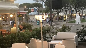 An outdoor seating area with wicker furniture and a central light fixture. - Hotel Cristina (Jesolo)