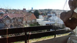 Blick von einem Balkon mit Geländer auf ein Wohngebiet mit Häusern und einem Wasserturm.