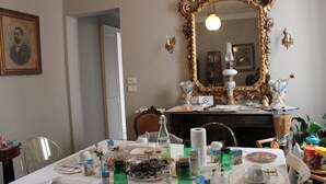 A dining area with a table set for a meal, a large ornate mirror, and a framed portrait on the wall. - B&B Il Ciottolo (Genoa)