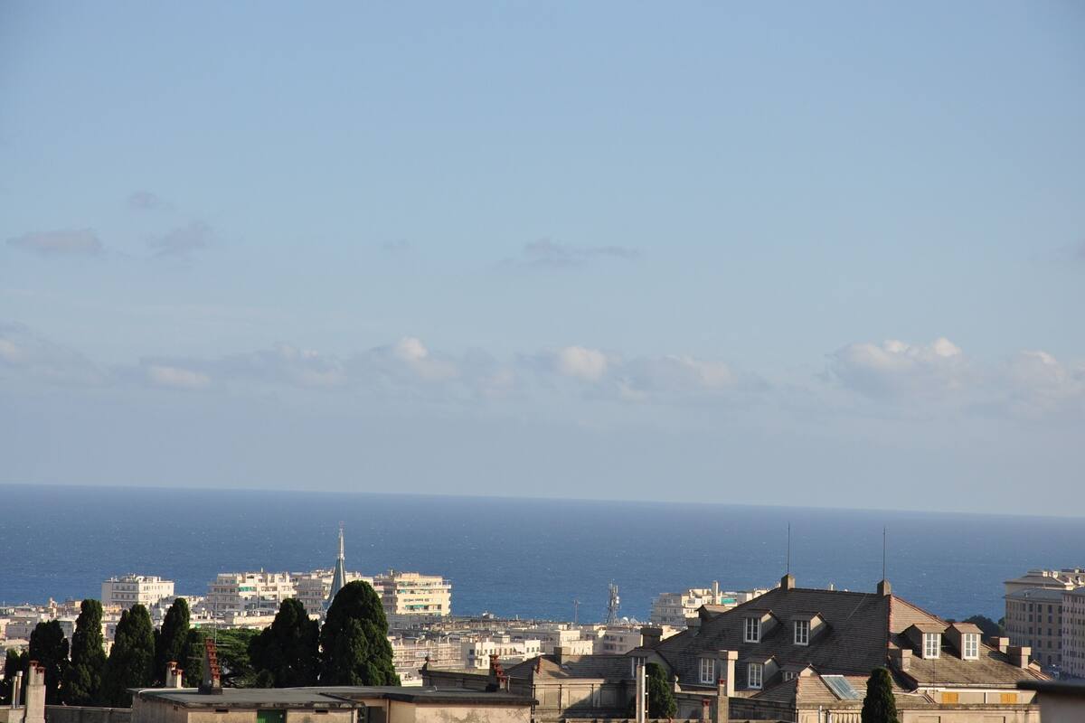 A coastal cityscape with buildings and a clear view of the sea.