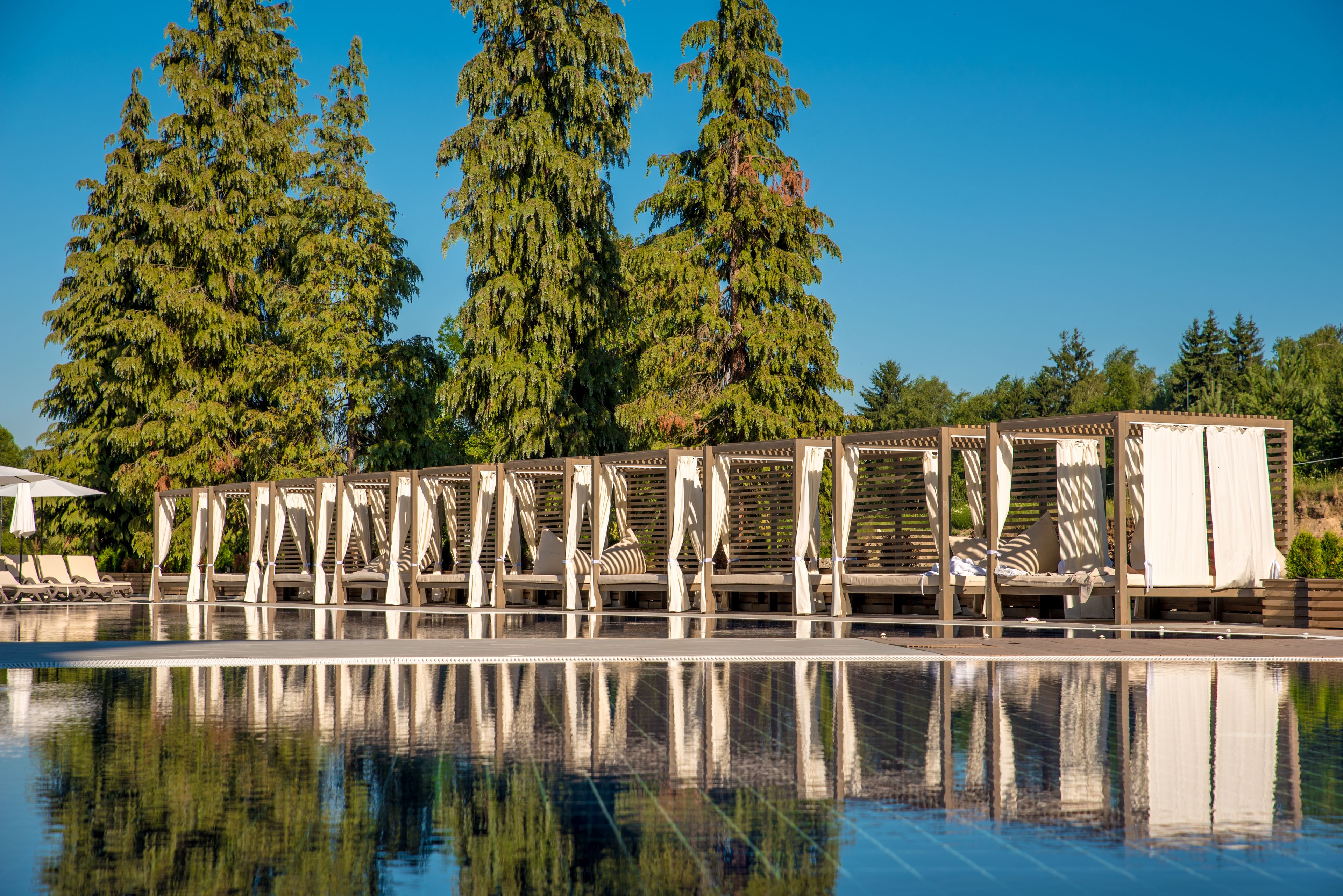 A pool area with lounge chairs and a pergola structure.