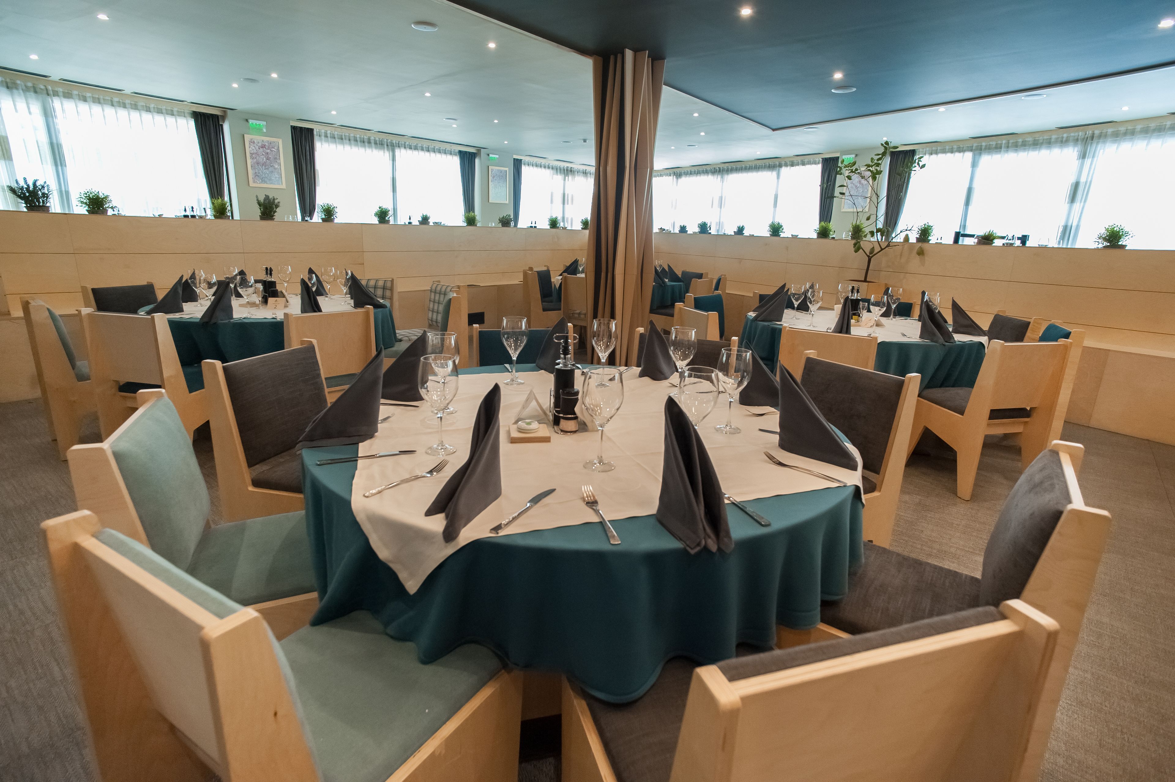 A conference room with round tables, chairs, and a large pillar.