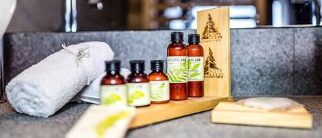 A bathroom vanity with a towel, soap, and a wooden box with a tree logo.