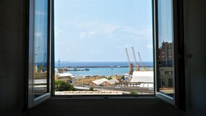 A view from a room with an open window overlooking a harbor with cranes and boats. - Romantica Mansarda Pisano (Genoa)