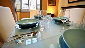A dining table set with green plates, wine glasses, and cutlery. - Dimora Lusso delle Vigne (Genoa)