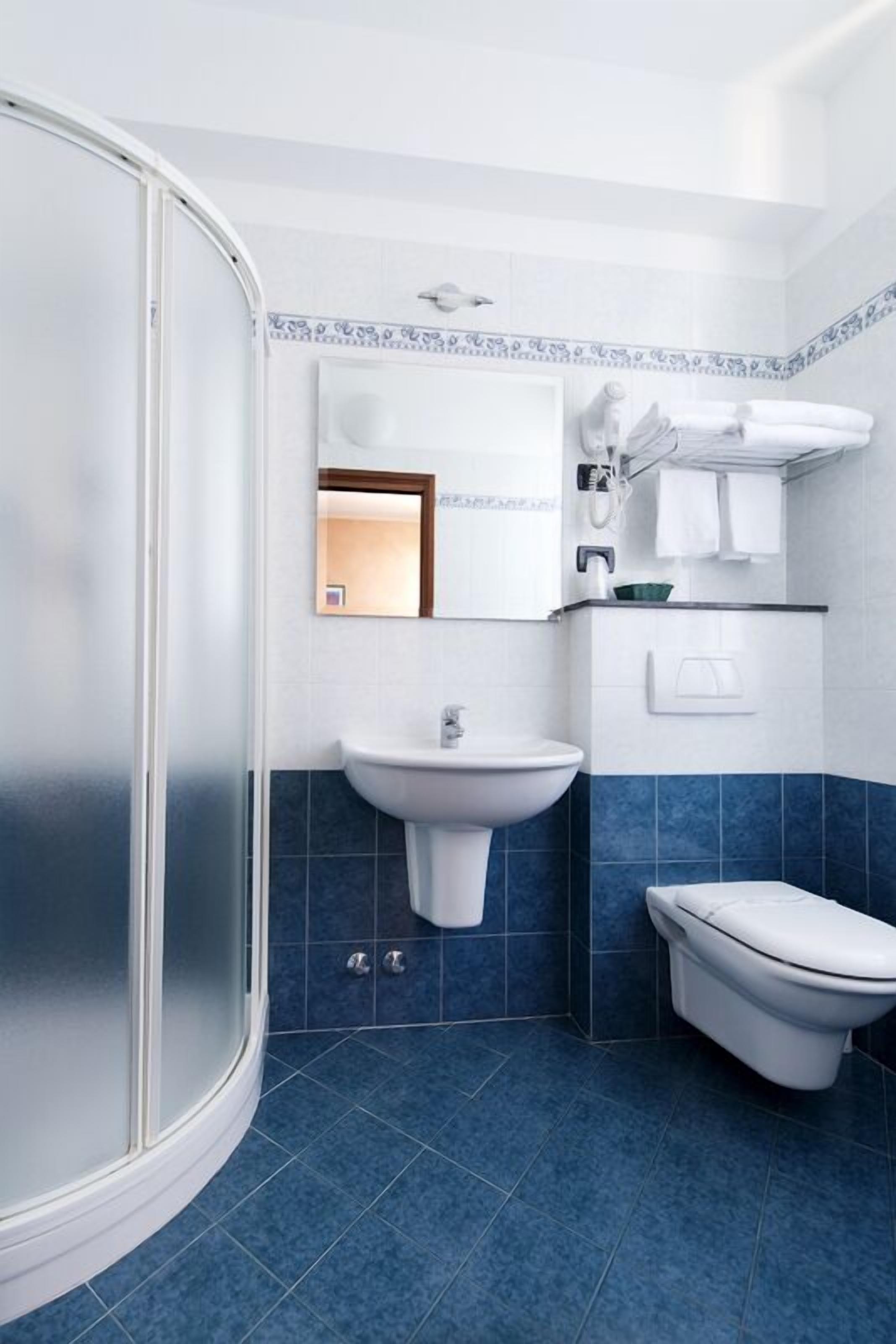 A bathroom with a shower, sink, and toilet.