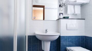 A bathroom with a shower, sink, and toilet.