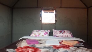 A small, enclosed room with a bed, a window, and a door. - Wadi Rum Candles Camp (Wadi Rum)