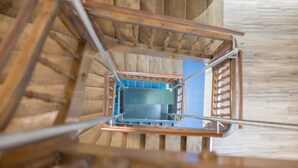 A wooden staircase with metal railings leading to a blue-tiled landing. - Albergo Diffuso (Porrentruy)