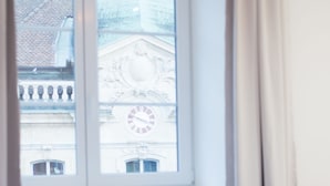 A room with a large window, a radiator, and a bed. - Albergo Diffuso (Porrentruy)